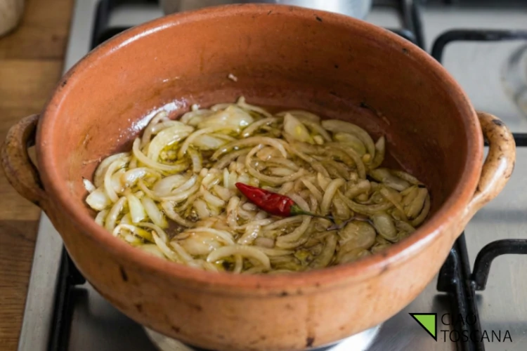 Soffritto lento nel coccio: le cipolle devono diventare trasparenti, mai bruciate. Soffritto lento nel coccio: le cipolle devono diventare trasparenti, mai bruciate.