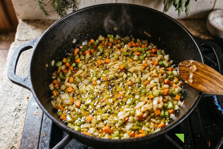 Soffritto toscano di cipolla, carota e sedano che rosola dolcemente in olio extravergine nel tegame in ghisa. Il primo segreto per un ragù alla chiantigiana perfetto Soffritto toscano di cipolla, carota e sedano che rosola dolcemente in olio extravergine nel tegame in ghisa. Il primo segreto per un ragù alla chiantigiana perfetto